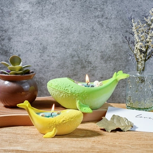Detailed view of whale-shaped scented candles with sea shells and rock texture finish