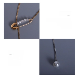 Detail of 18K gold-plated safety pin pendant with imitation pearls on titanium steel chain
