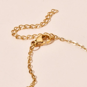 Detail of golden stainless steel necklace chain with secure lobster clasp and extender