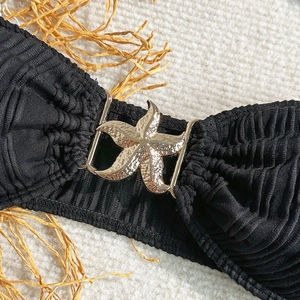 Close-up of black textured bikini top with a decorative golden starfish metal buckle