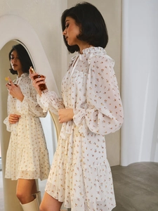 Dettaglio dell'abito in chiffon a fiori con colletto a balze e fiocco allo scollo