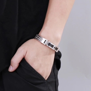Detail of silver stainless steel men's bracelet with carbon fiber inlay on a wrist
