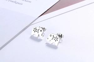 Macro shot of silver elephant stud earrings with floral hollow patterns and crystal eye