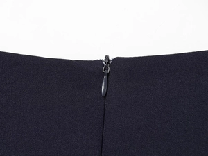 Detail view of the high-quality invisible zipper closure on the black rivet mini dress