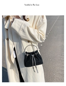 Close-up of black mini bucket bag with silver studs and tassel drawstring detail