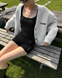 Dettaglio del cardigan grigio in maglia con logo STRESSMAMA in stile sportivo