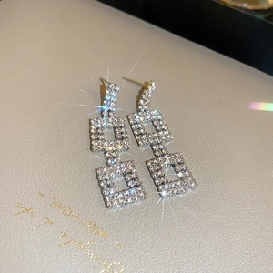 Macro detail of silver geometric square earrings with sparkling crystal pavé setting
