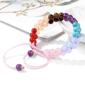 Detail of multi-color natural tiger eye stone braided bracelet with adjustable pink cord