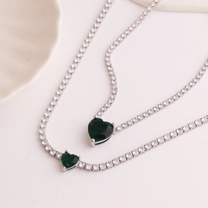 Silver tennis chain necklace featuring a brilliant green heart-shaped zircon pendant