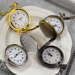 Detailed view of vintage Alice-themed pocket watches in four finishes on a ceramic plate