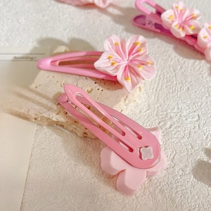 Detail shot of pink cherry blossom hair clips with resin flowers and metal BB clips