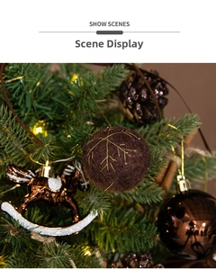 Brown plush Christmas ball with gold snowflake embroidery on a green pine tree