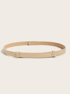 Detail view of beige Saffiano leather skinny belt with silver buckle on neutral background