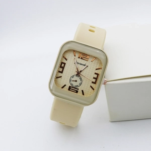 Detailed close-up of a square quartz watch with cream silicone strap and gold dial texture