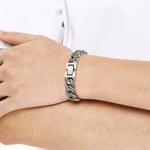 Close-up of vintage engraved Cuban chain bracelet in antique silver on male wrist
