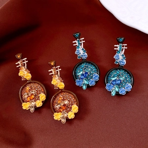 Detail view of vintage pipa-shaped earrings with intricate floral rhinestones and crystals