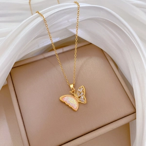 Macro shot of gold butterfly necklace pendant with pink inlay and sparkling zircons