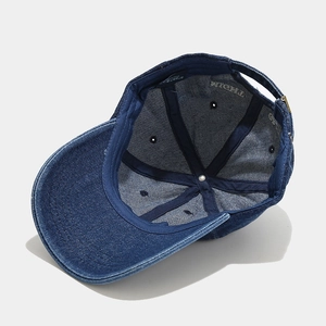 Inside view of denim baseball cap showing reinforced stitching and adjustable metal buckle