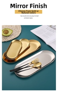 Detail of gold and silver stainless steel oval trays with mirror finish and cutlery
