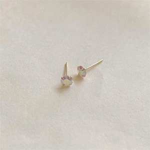 Macro shot of minimalist four-prong iridescent stud earrings with gold plating