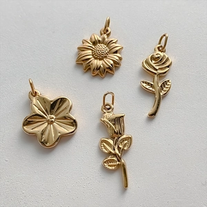 Set di quattro ciondoli floreali vintage in acciaio inossidabile dorato con varie forme