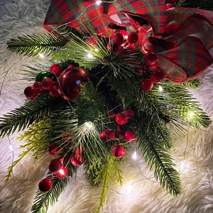 Detail of Christmas teardrop swag with red berries, pine needles, and LED lights