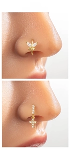 Detail of gold butterfly and cross nose rings with sparkling white zircon inlays