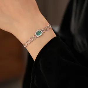 Vintage silver hollow mesh bracelet with green zircon oval gemstone worn on wrist