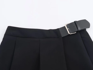 Détail de la taille d'une jupe-culotte plissée noire avec ceinture à boucle carrée argentée
