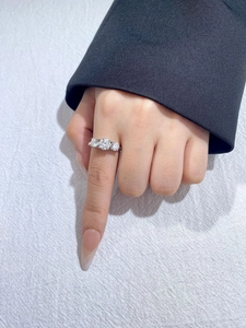 Detailed macro view of a 1-carat moissanite ring with classic four-prong trilogy setting