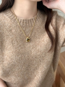 Detail showing vintage gold square pendant with tiger eye stone and snake chain