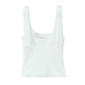Detailed view of white minimalist camisole top featuring elegant oversized bow shoulder straps