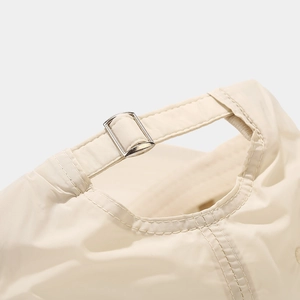 Detail of the adjustable silver metal buckle on a breathable cream outdoor sun hat
