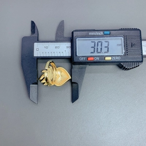 Close-up measurement of a gold wing heart ring showing a precise dimension of 30.3 mm