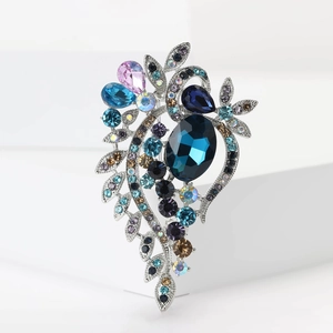 Macro detail of luxury vintage brooch with deep blue gemstones and silver leaf metalwork