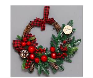 Detail of Christmas wreath with pine needles, red berries, and merry christmas engraving