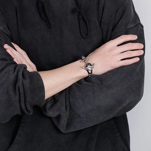 Détail d'un bracelet ancre pour homme avec cordon tressé noir porté au poignet