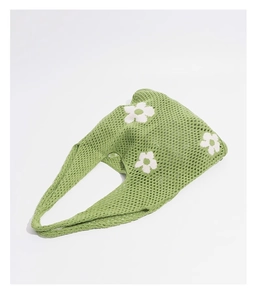 Detailansicht der grünen Stricktasche mit Mesh-Muster und weißen Gänseblümchen