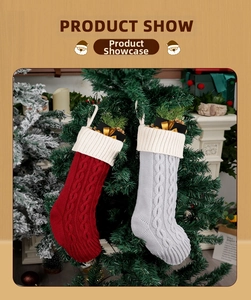 Detail of red and grey cable knit Christmas stockings hanging on a green Xmas tree