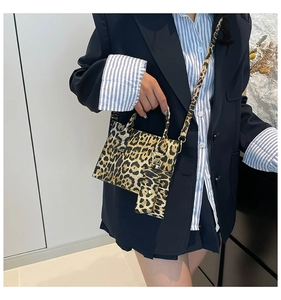 Detail view of stylish leopard print shoulder bag with matching mini pouch on model