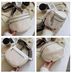 Close-up of white pebble leather waist bag with double zippers and striped wide strap
