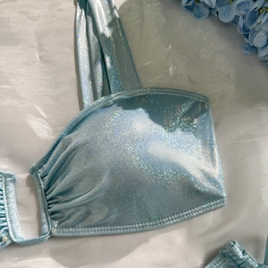Close-up of light blue metallic shimmer bikini fabric with scale texture and ruched detail