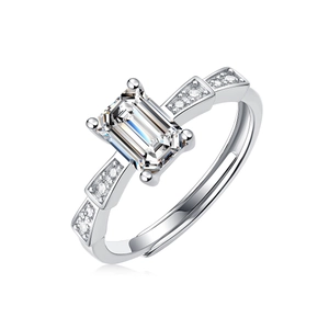 Detailed close-up of emerald cut stone ring with side diamond accents on silver band
