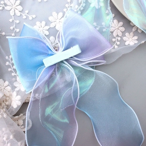 Detail of gradient bow hair clip with translucent glitter fabric and long ribbon