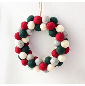 Close-up of wool felt ball garland with red, green, gray, and white spheres for Christmas