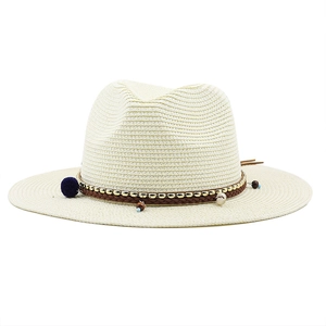 Détail d'un chapeau de paille Fedora bohème avec franges à glands et perles décoratives