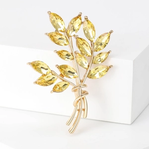 Macro shot of gold wheat brooch with marquise-cut yellow crystals and metallic finish