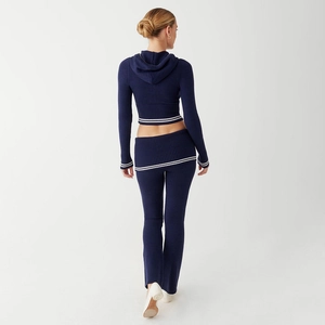 Rear view of navy blue knitted two-piece set with white stripes on a walking model