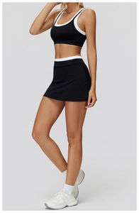 Detail view of contrast trim yoga set featuring black sports bra and athletic skirt