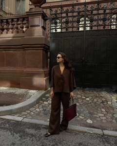 Detail of loose dark brown linen set with tie-front long sleeve top and wide-leg trousers